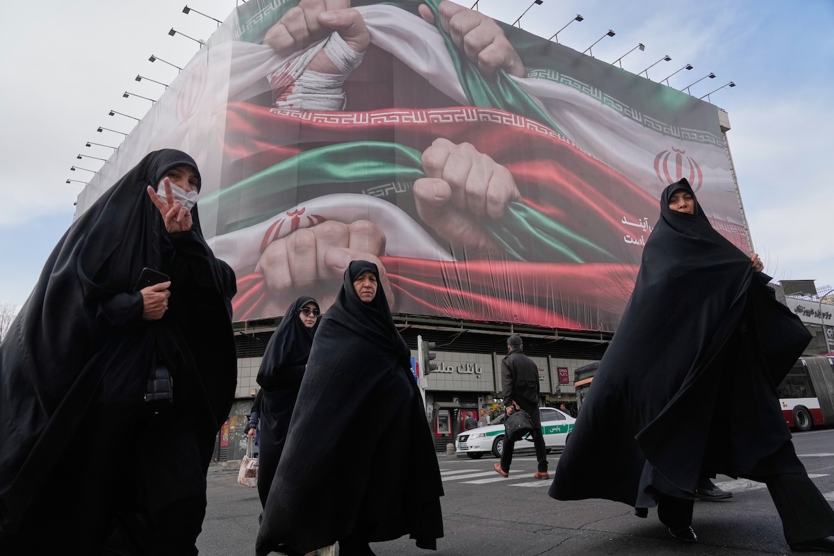 La quasi totalità delle foto che arrivano dall'Iran sono quelle approvate dalla censura: in questa, del 14 gennaio, alcune donne camminano davanti a un cartellone propagandistico a Teheran
