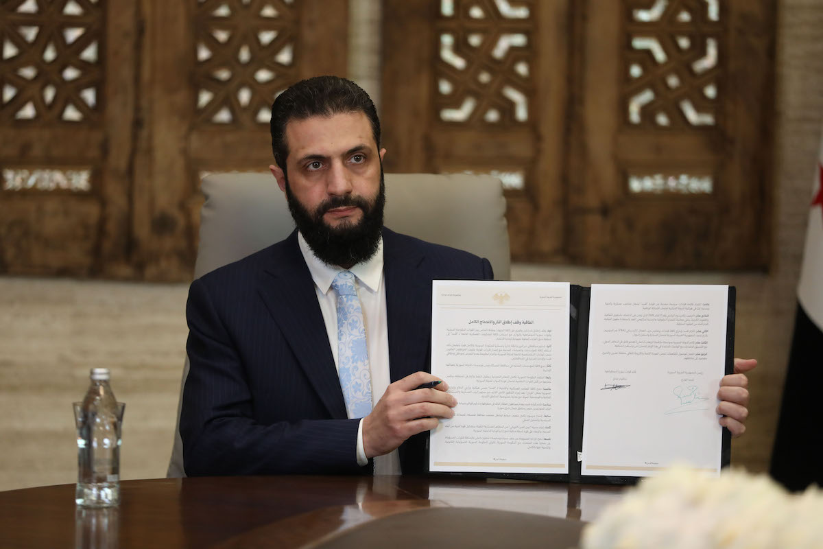 Ahmed al Sharaa mostra l'accordo per il cessate il fuoco, 18 gennaio 2026 (Getty Images)