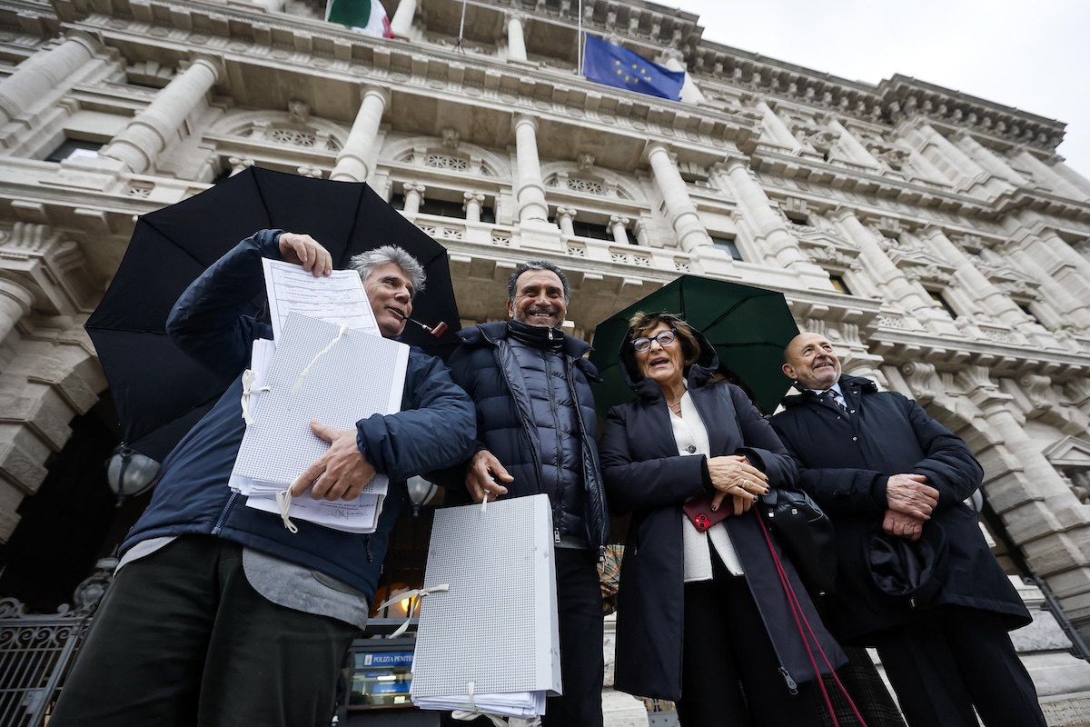 Carlo Guglielmi (a sinistra, con la pipa), portavoce del Comitato dei 15 cittadini che ha promosso la raccolta firme sul referendum, durante la deposizione delle firme alla Corte di Cassazione, a Roma il 28 gennaio 2026 (ANSA/ANGELO CARCONI)