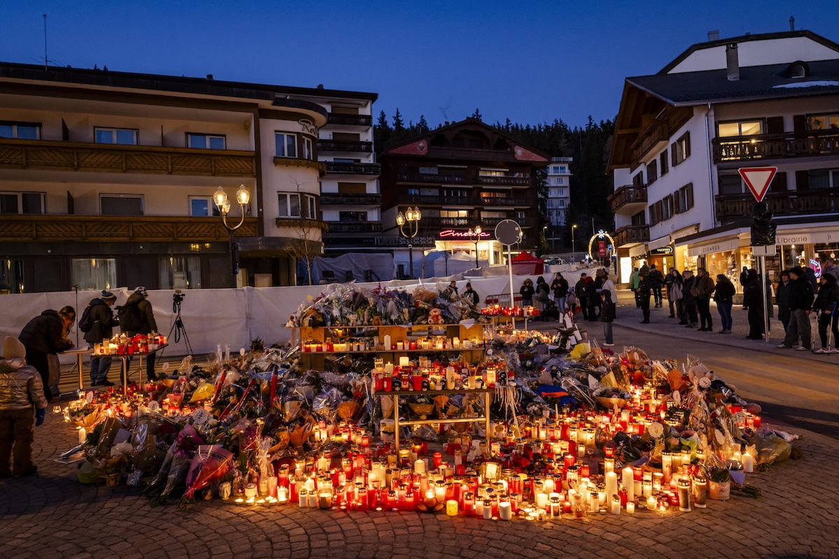 Fiori e candele davanti al Le Constellation, a Crans-Montana (EPA/JEAN-CHRISTOPHE BOTT)