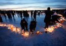Alcuni attivisti sul lago ghiacciato di Nokomis, a Minneapolis, accendono candele per formare la scritta "ICE OUT" (fuori l'ICE) (AP Photo/Alex Brandon)