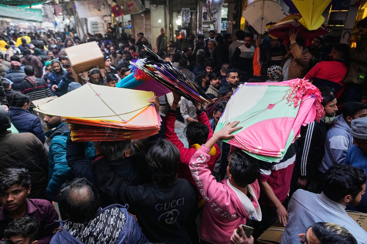 Alcune persone con diversi aquiloni in un mercato di Lahore, il 2 febbraio (AP/K.M. Chaudary)