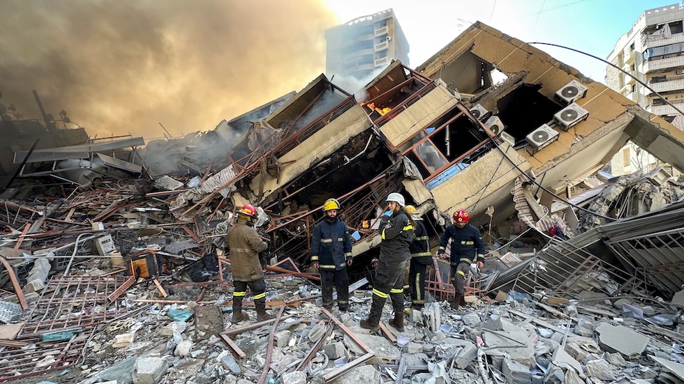 Membri della Difesa Civile libanese davanti alle rovine di un edificio distrutto da un bombardamento israeliano, il 9 marzo 2026 (REUTERS/Stringer)