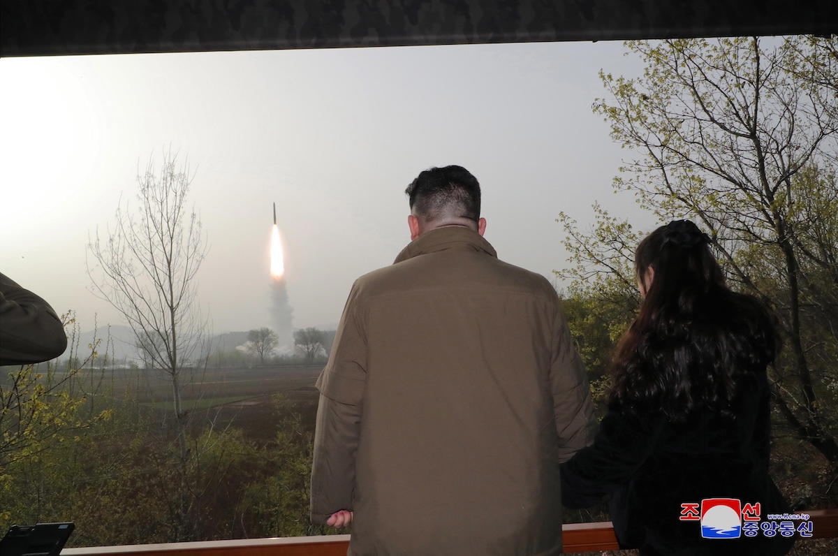 Padre e figlia assistono al lancio di un missile, aprile 2023 (Korean Central News Agency)