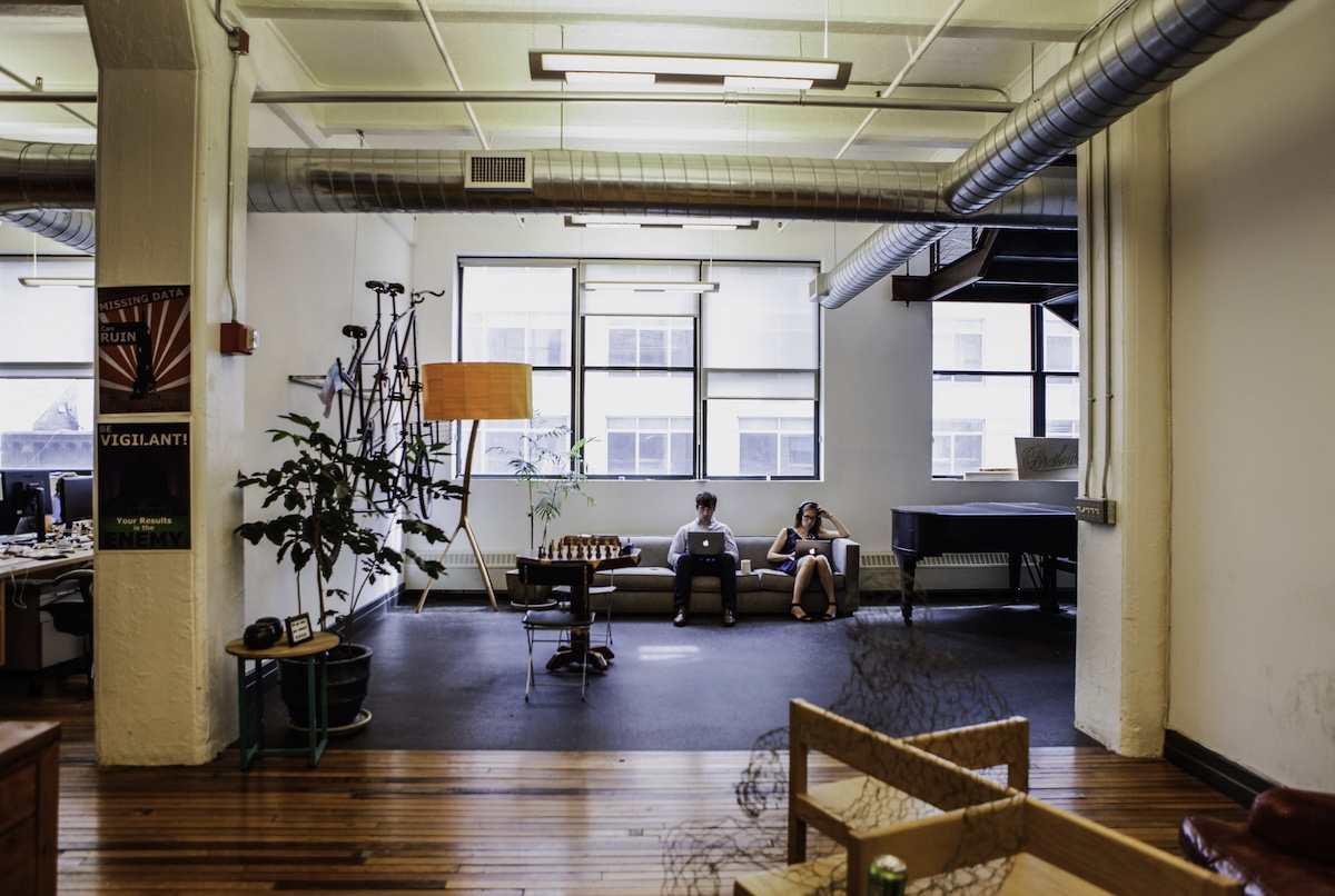 Due dipendenti mentre lavorano seduti su un divano