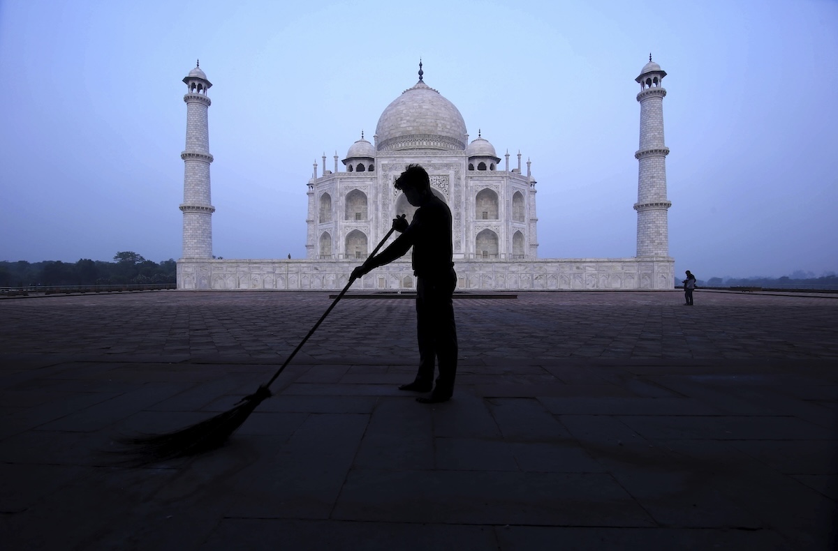 Un uomo spazza la piazza principale davanti al Taj Mahal, prima che venga aperto ai turisti (AP/Pawan Sharma)