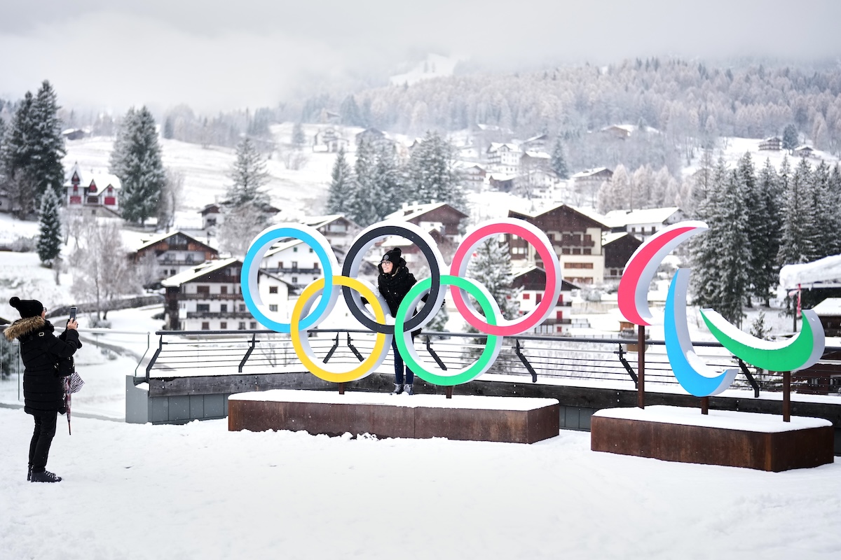 Una persona scatta una foto a un'altra davanti al Simbolo dei Giochi Olimpici e Paralimpici a Cortina D'Ampezzo, lo scorso 20 novembre 2025 (AP Photo/Andrew Medichini, File)