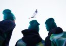 I volontari che lavorano alle Olimpiadi guardano Kaila Kuhn, degli Stati Uniti, che si allena prima della finale di sci freestyle aerials a squadre.