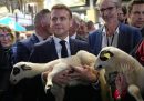 Il presidente francese Emmanuel Macron tiene in mano una pecora durante la visita alla Fiera Internazionale dell'Agricoltura.