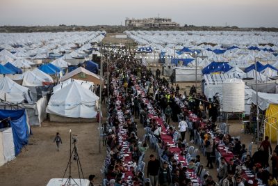 Persone che partecipano a un iftar (pasto con cui si interrompe il digiuno nel mese del Ramadan) di massa, in un campo di tende che ospitano i palestinesi sfollati dalla città di Gaza.