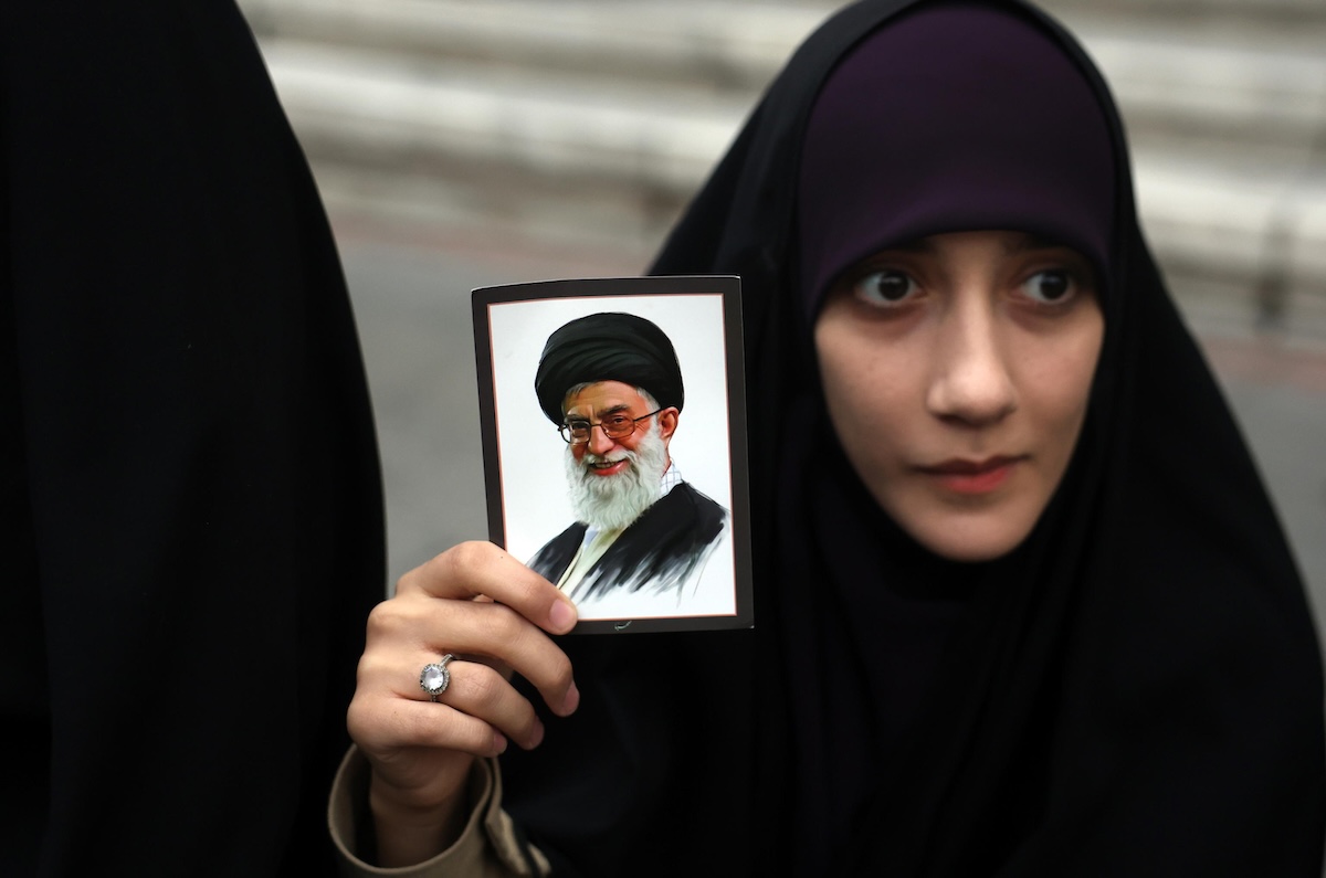 Una donna con una foto di Ali Khamenei durante una manifestazione organizzata a Teheran dal regime, il 28 febbraio 