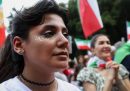 Una ragazza in primo piano, con la parola “Iran” scritta con un inchiostro bianco sullo zigomo