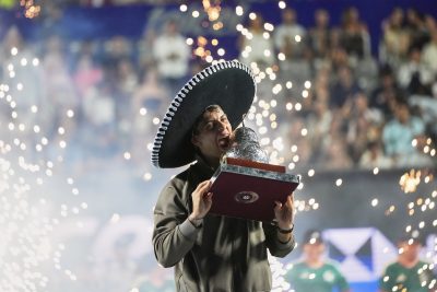 Cobolli mentre addenta un trofeo