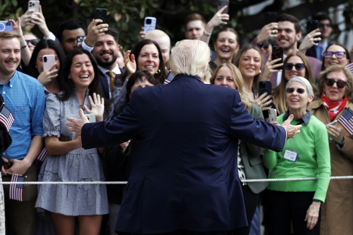 Donald Trump, di spalle, parla con i giornalisti alla Casa Bianca, l'11 marzo