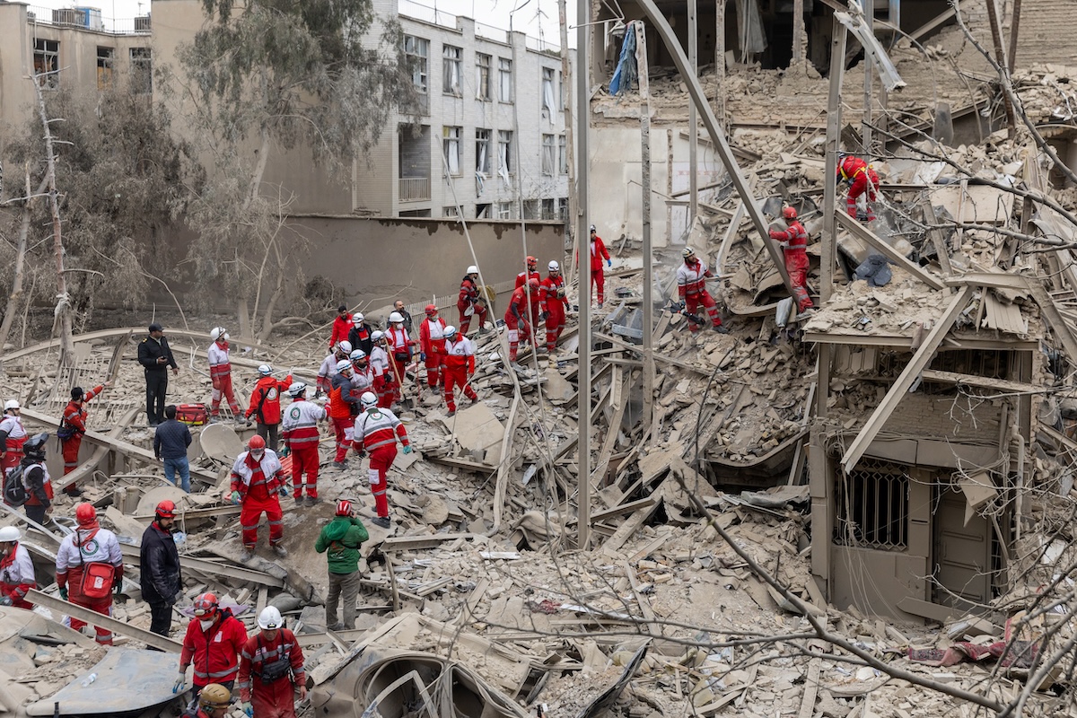 Soccorritori tra le macerie di un palazzo distrutto da un bombardamento a Teheran, il 16 marzo
