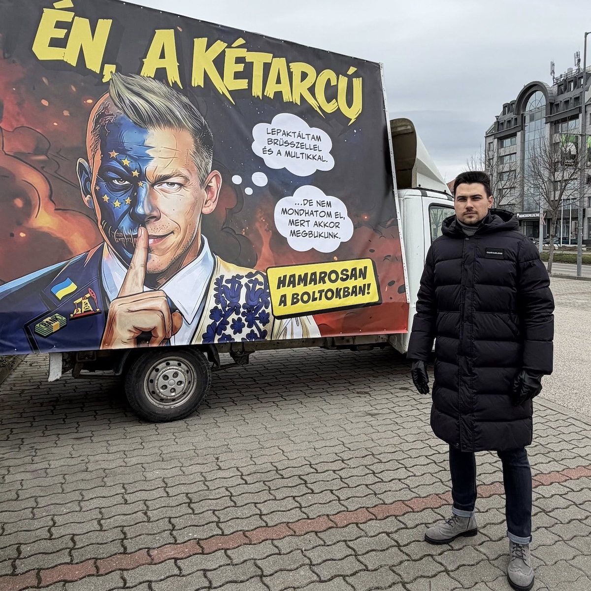 Gábor Szűcs, il leader del Movimento di Resistenza Nazionale, di fronte a una pubblicità di “Io, Due Facce”, a inizio febbraio (foto tratta dal profilo Facebook del Movimento di Resistenza Nazionale)