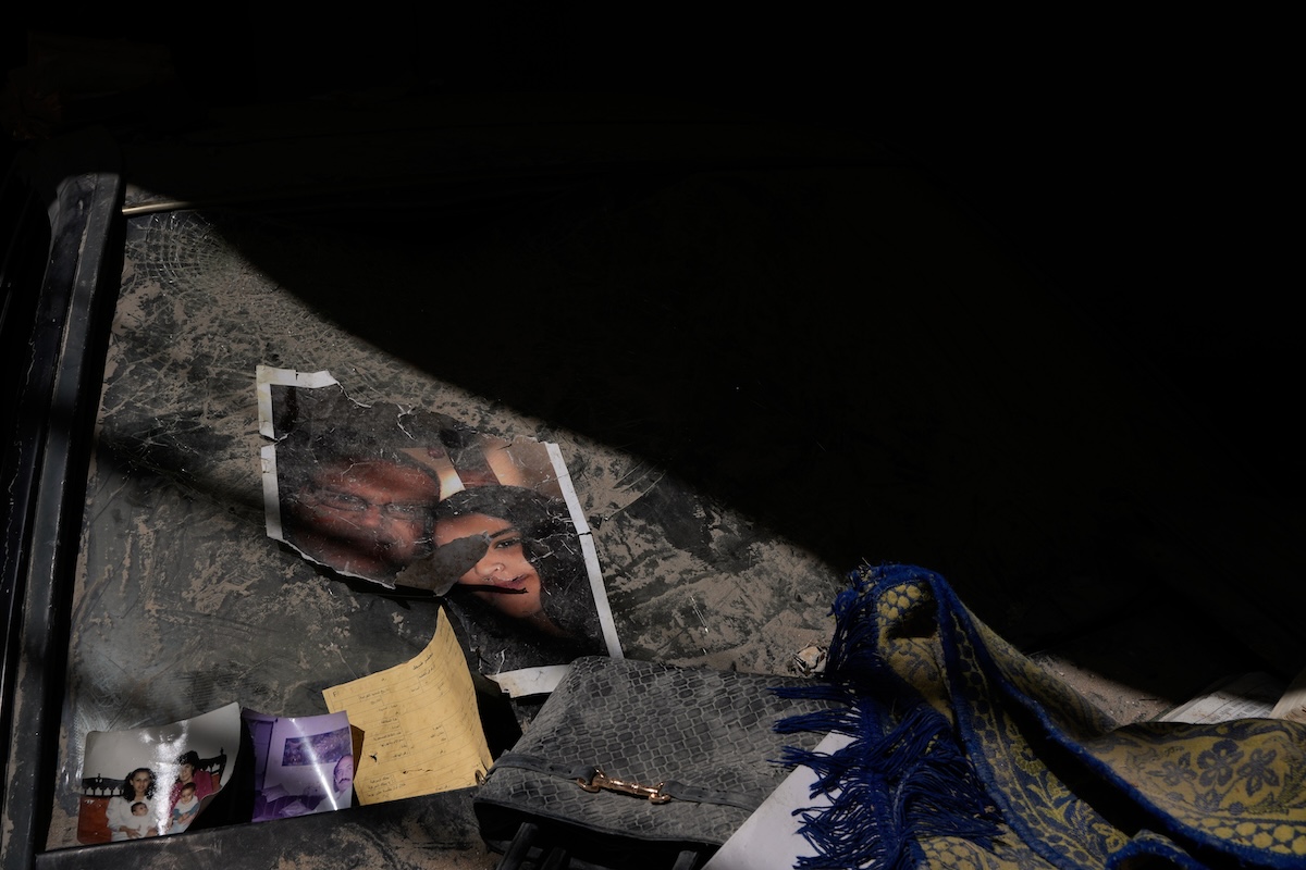 Alcune foto sul finestrino di una macchina vicino a un palazzo distrutto da un bombardamento israeliano, a Beirut, il 16 aprile 2026 (AP Photo/Hussein Malla)