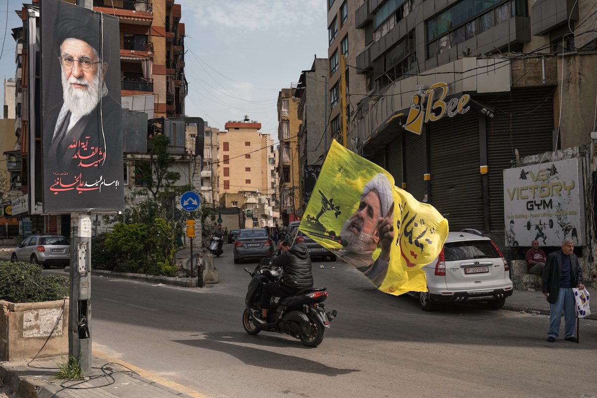 Un uomo con una bandiera di Hezbollah, il 17 aprile nel quartiere Dahiyeh di Beirut