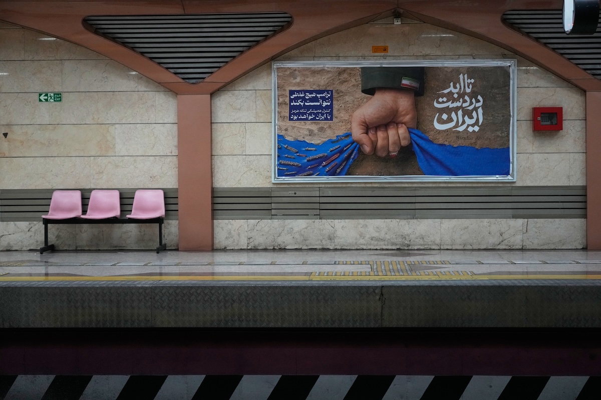 Un manifesto della propaganda iraniana a Teheran, con una mano che chiude lo stretto di Hormuz e la scritta “Per sempre nelle mani dell'Iran”, il 17 aprile 2026 (AP Photo/Vahid Salemi)