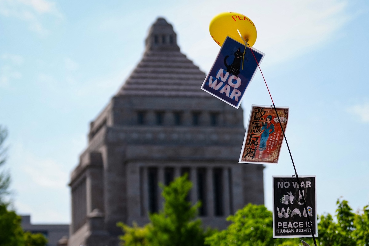 Cartelli con scritto «no alla guerra» sotto il complesso del parlamento giapponese, a Tokyo, il 19 aprile