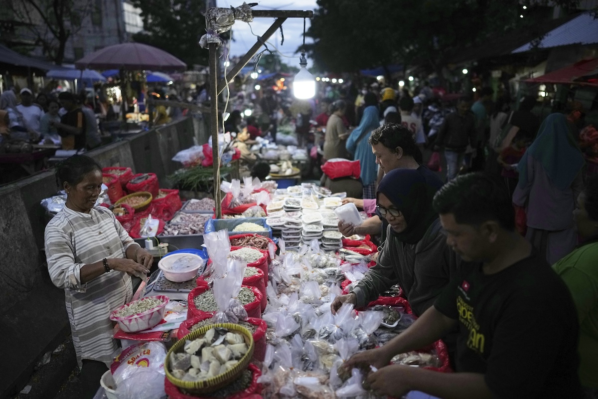 Una venditrice di strada a Jakarta, nel marzo del 2025 (AP Photo/Dita Alangkara)