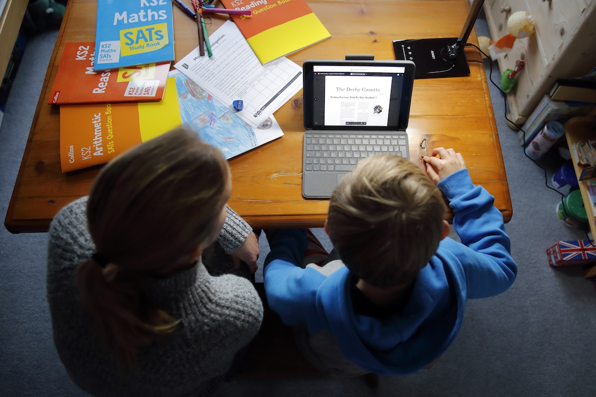 Un bambino mentre usa un tablet vicino alla madre