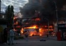 Alcuni passanti guardano l'incendio di un edificio causato da un bombardamento russo a Kiev, il 24 maggio (AP Photo/Evgeniy Maloletka)