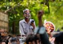 Un ragazzo con la maschera di uno scarafaggio sul volto