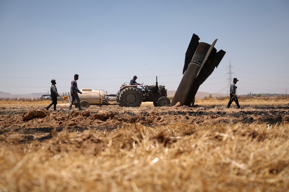 Contadini vicino ai resti di un missile iraniano diretto verso Israele (AP Photo/Ghaith Alsayed)