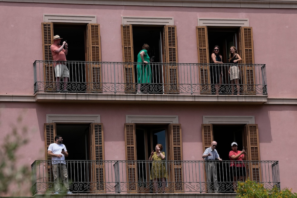 Persone affacciate ai balconi in attesa di papa Leone XIV, che ha celebrato messa nella cattedrale della Santa Croce e Sant'Eulalia (AP Photo/Alessandra Tarantino)
