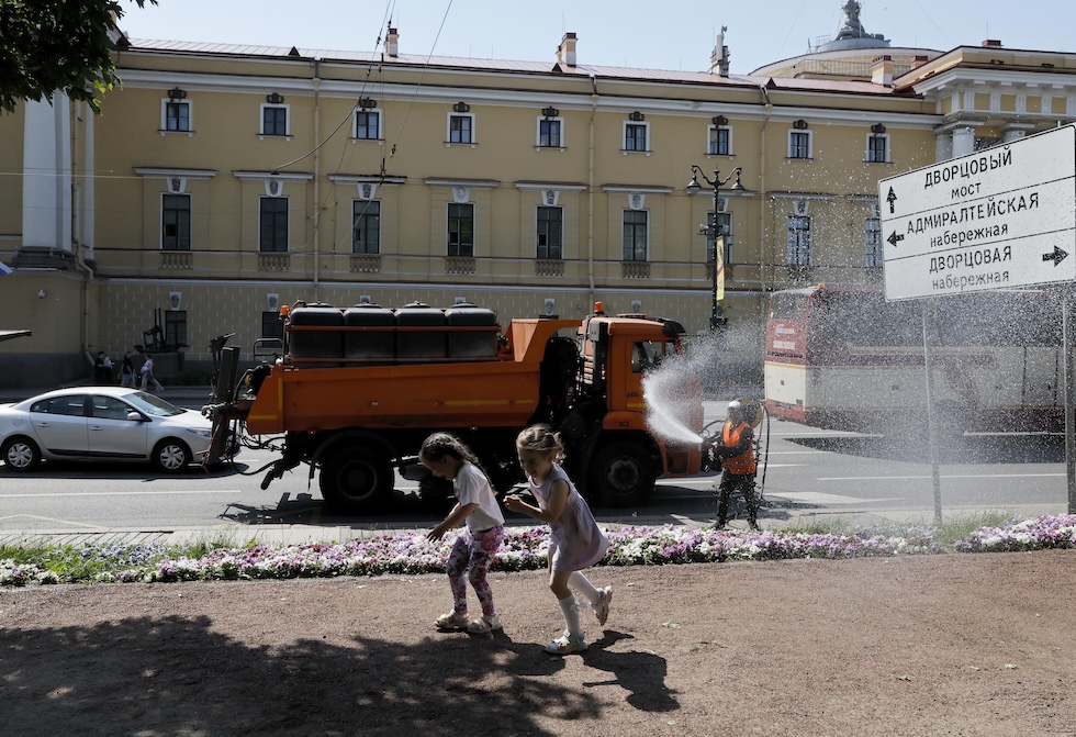 Due bambine mentre vengono spruzzate con l'acqua di un irri (EPA/ANATOLY MALTSEV/ansa)
