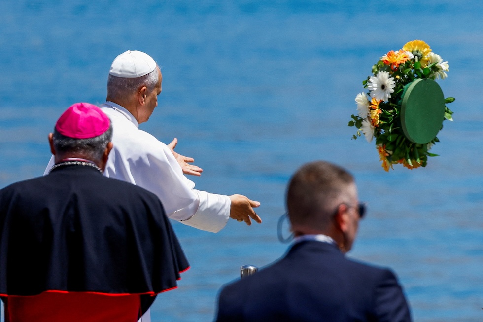 Papa Leone XIV lancia dei fiori in ricordo delle persone migranti morte in mare, al porto di Arguineguin (REUTERS/Borja Suarez)
