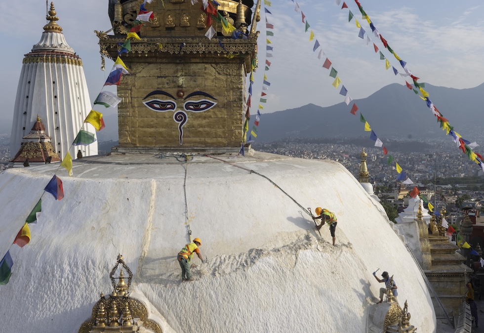 Operai impegnati in lavori di restauro sulla cupola dello Swayambhu, un importante stupa buddista. L'obiettivo dei lavori di restauro è ridurre il peso della struttura rimuovendo alcuni strati di calce, per preservare meglio la struttura e minimizzare il potenziale impatto di disastri naturali come terremoti (EPA/NARENDRA SHRESTHA/ansa)
