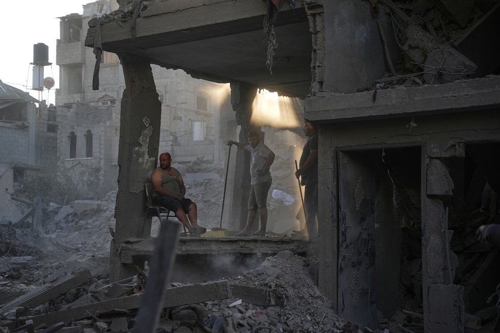 Palestinesi in un edificio distrutto dai bombardamenti israeliani nel campo profughi di Al Maghazi(AP Photo/Abdel Kareem Hana)
