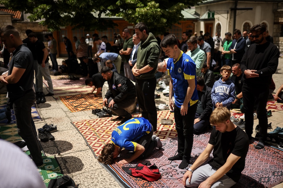 Uomini musulmani, alcuni con la maglia della nazionale di calcio bosniaca, pregano durante la preghiera del venerdì (AP Photo/Armin Durgut)

