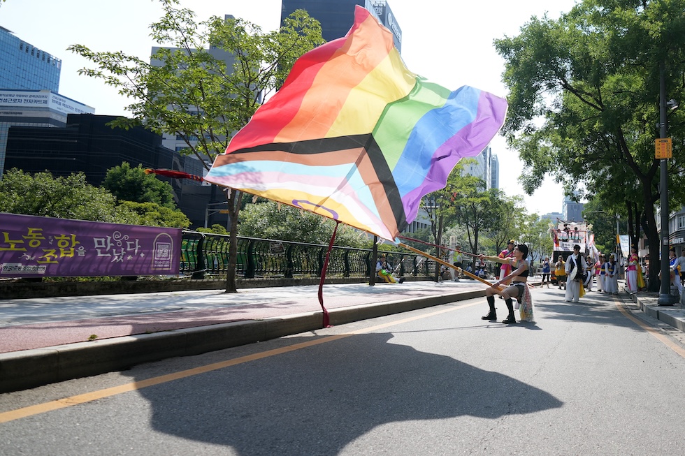 Un parteciapante del "Seoul Queer Culture Festival" con una grande bandiera della comunità LGBTQIA+ (AP Photo/Lee Jin-man)

