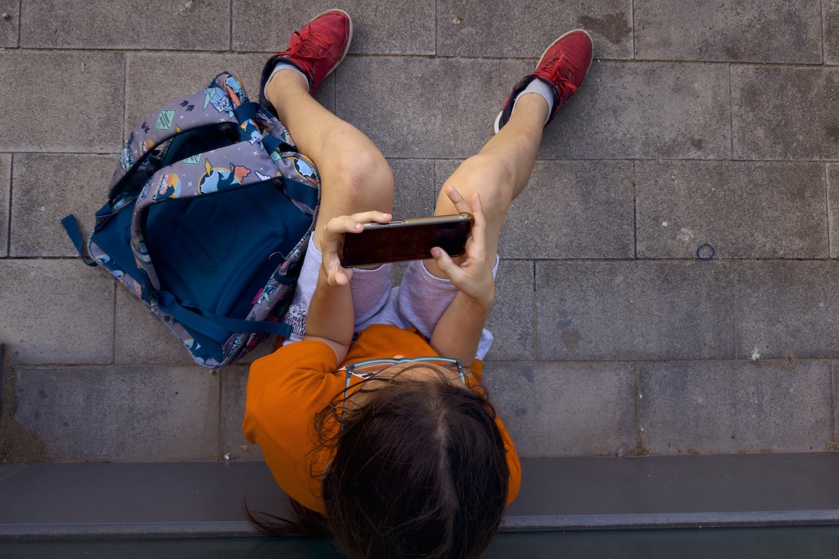 Una undicenne gioca con uno smartphone