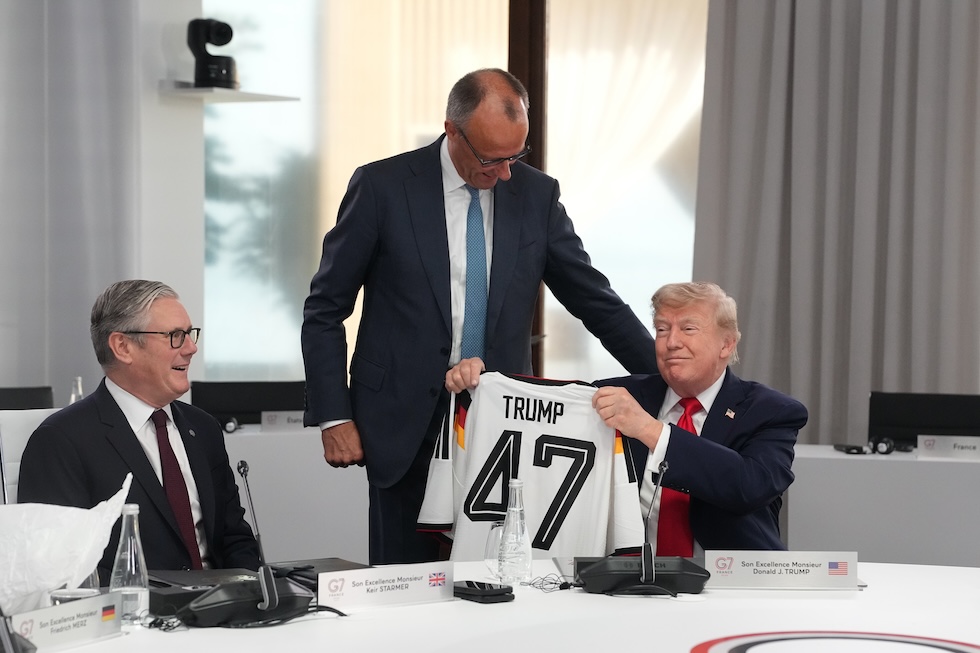 Il presidente degli Stati Uniti Donald Trump con una maglia della nazionale tedesca con il numero 47 che gli è stata donata dal cancelliere tedesco Friedrich Merz, al G7 (AP Photo/Thibault Camus)