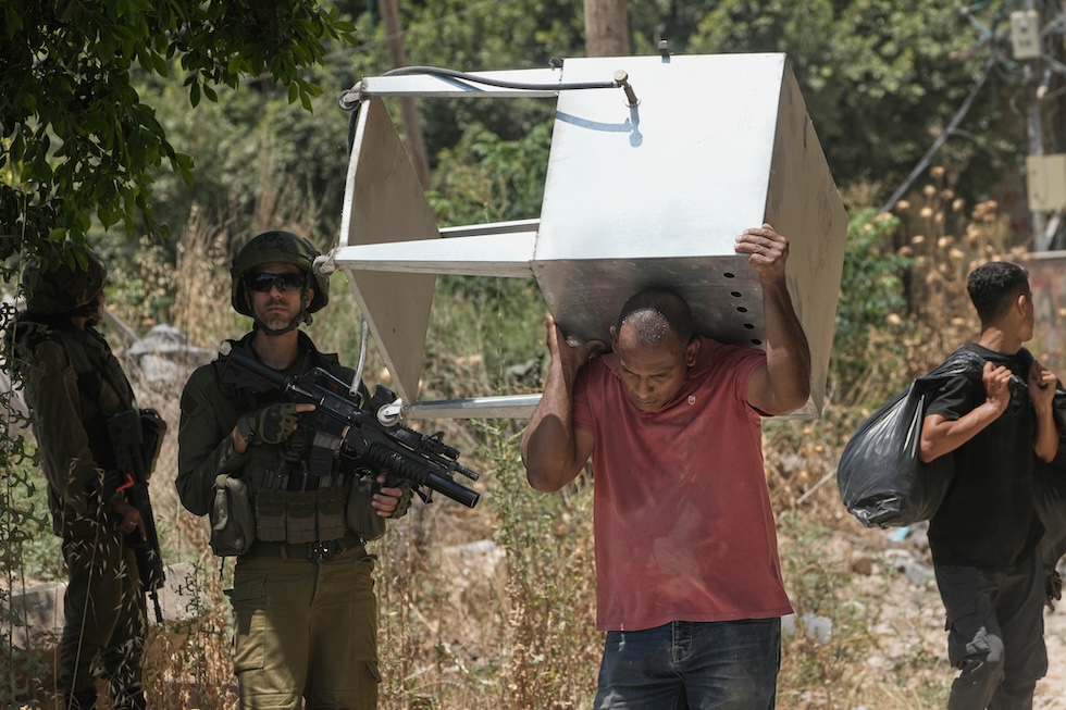 Palestinesi del campo profughi di Tulkarem recuperano mobili e altri effetti personali dalle loro case, che avevano dovuto lasciare dopo le operazioni militari di Israele, dopo che l'esercito ha rilasciato una serie di permessi di accesso a breve termine  (AP Photo/Majdi Mohammed)
