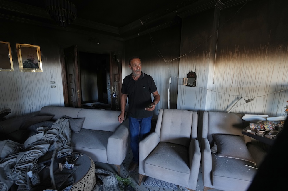 Un uomo nel suo apparamento danneggiato dai bombardamenti israeliani (AP Photo/Hassan Ammar)