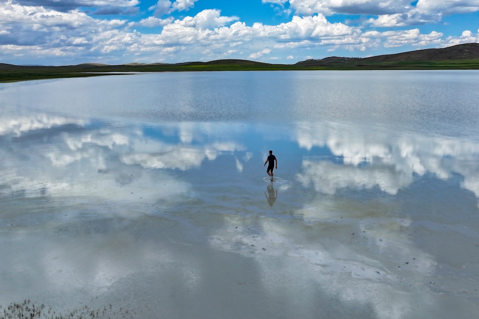 Una persona cammina sulle acque basse del lago Akgöl (Ozkan Bilgin/Anadolu via Getty Images)