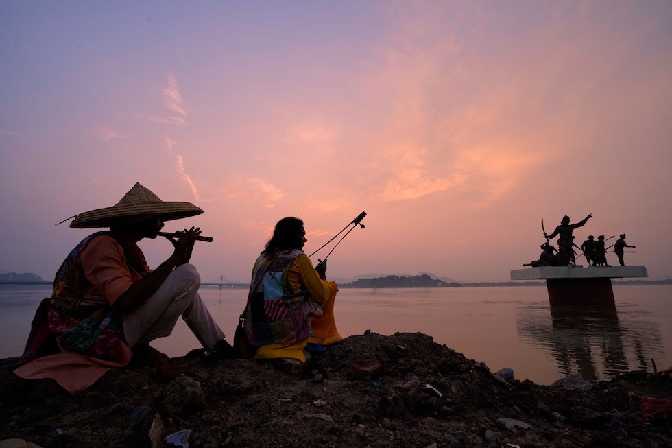 Artisti baul, cantastorie itineranti originari del Bangladesh e dello stato indiano del Bengala Occidentale, si esercitano al tramonto lungo il fiume Brahmaputra (AP Photo/Anupam Nath)
