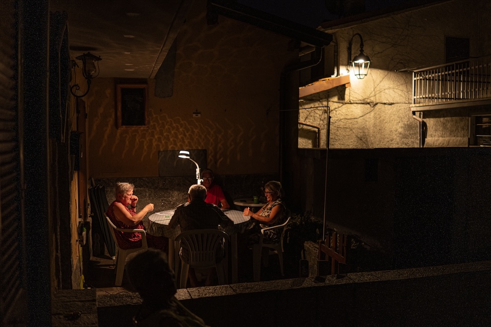 Un gruppo di pensionati gioca a carte all'aperto, ieri sera (Alessandro Levati/Getty Images)

