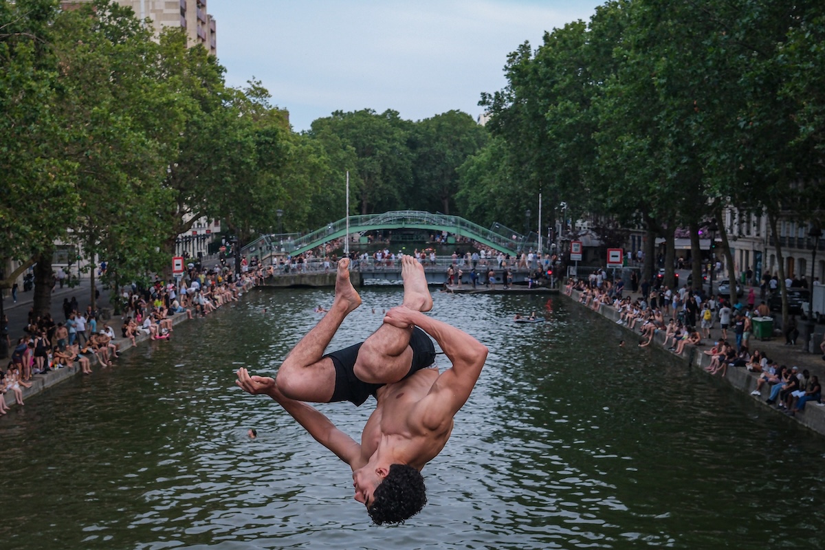 Un uomo si tuffa nel canale Saint-Martin, a Parigi. (Photo by Annice Lyn/Getty Images)
