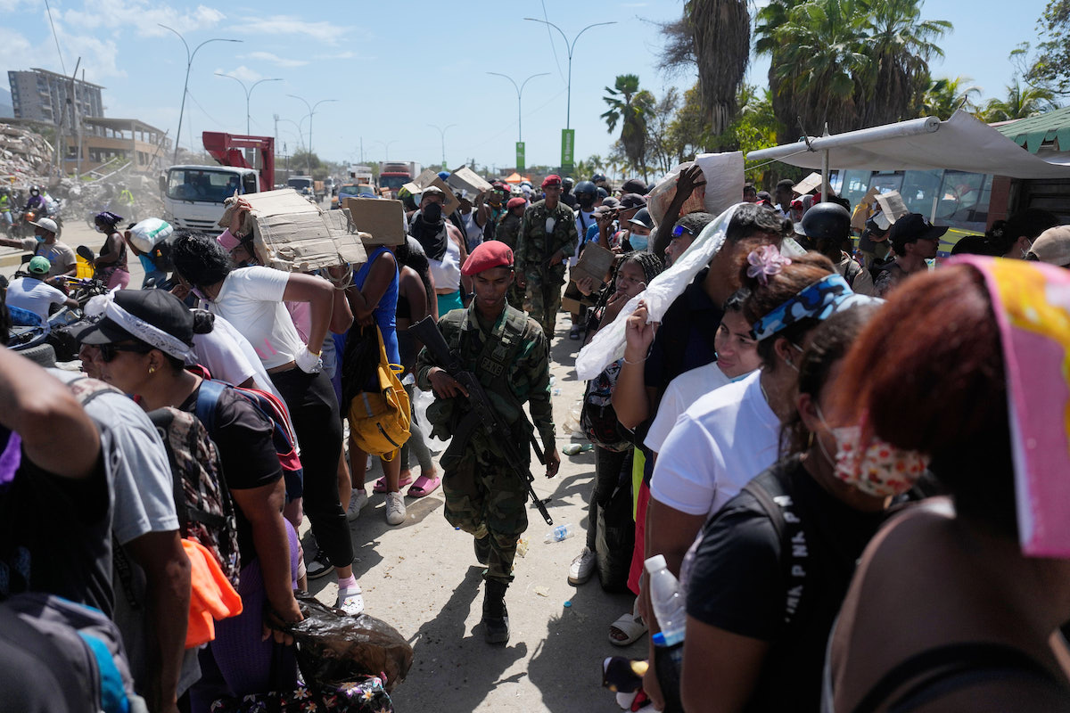 Un soldato cammina armato tra i sopravvissuti a La Guaira, 28 giugno 2026 (AP Photo/Fernando Vergara)