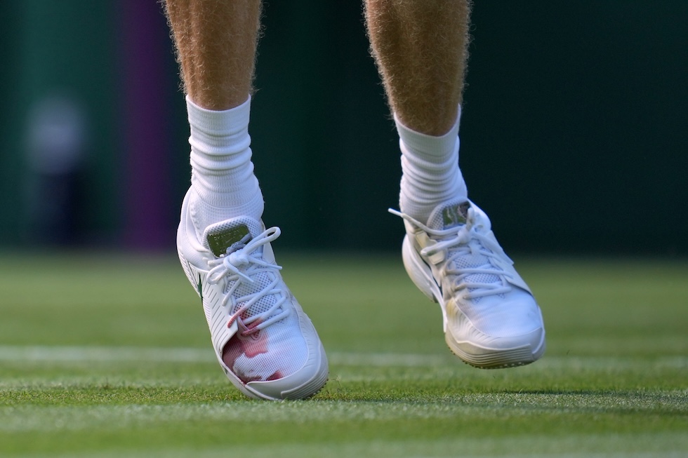 La scarpa di Jannik Sinner, con una macchia di sangue (lui ha detto per via di un'unghia, senza specificare altro), durante la partita che ha vinto contro Miomir Kecmanovic al torneo di Wimbledon (AP Photo/Kin Cheung)
