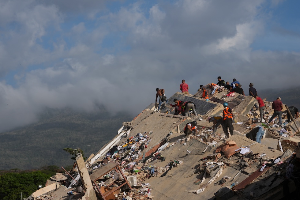 Soccorritori tra le macerie di un edificio crollato per i terremoti dei giorni scorsi, che hanno ucciso almeno 1.719 persone (AP Photo/Matias Delacroix)
