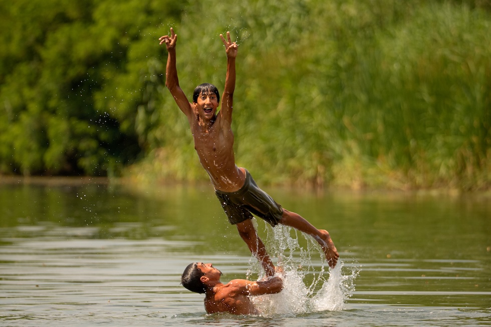 Due ragazzi giocano in un fiume  (AP Photo/ Andreea Alexandru)
