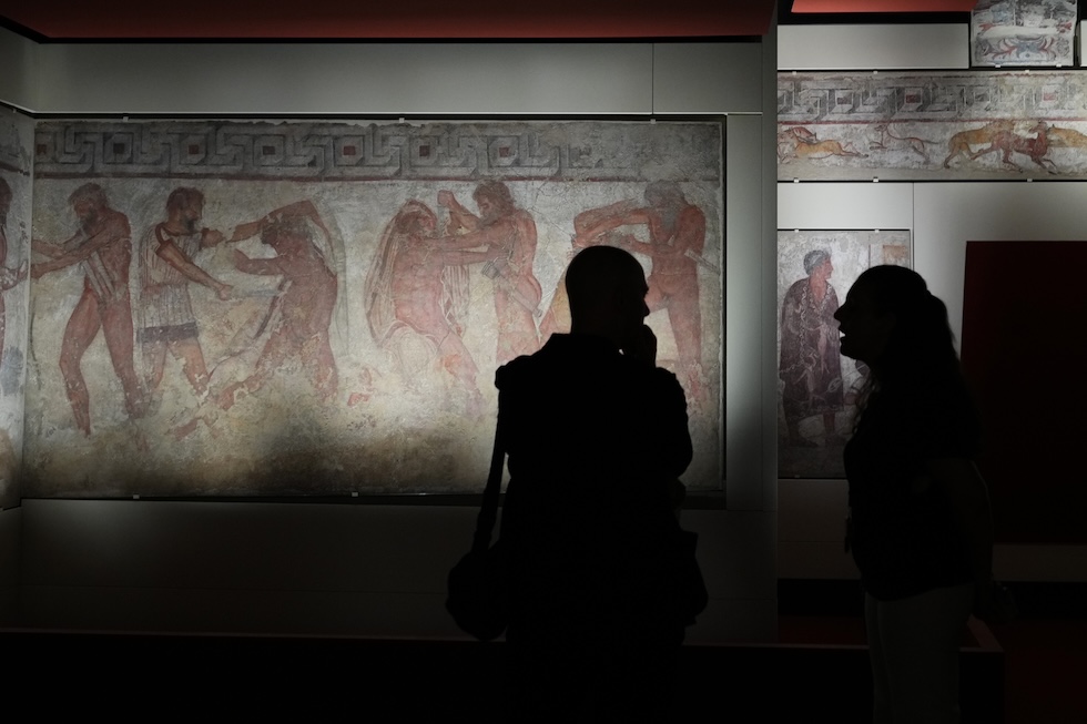 Alcune persone davanti agli affreschi della tomba François, una tomba etrusca della necropoli di Vulci, acquisita dal ministero della Cultura, al Museo Nazionale Etrusco di Villa Giulia  (AP Photo/Alessandra Tarantino)
