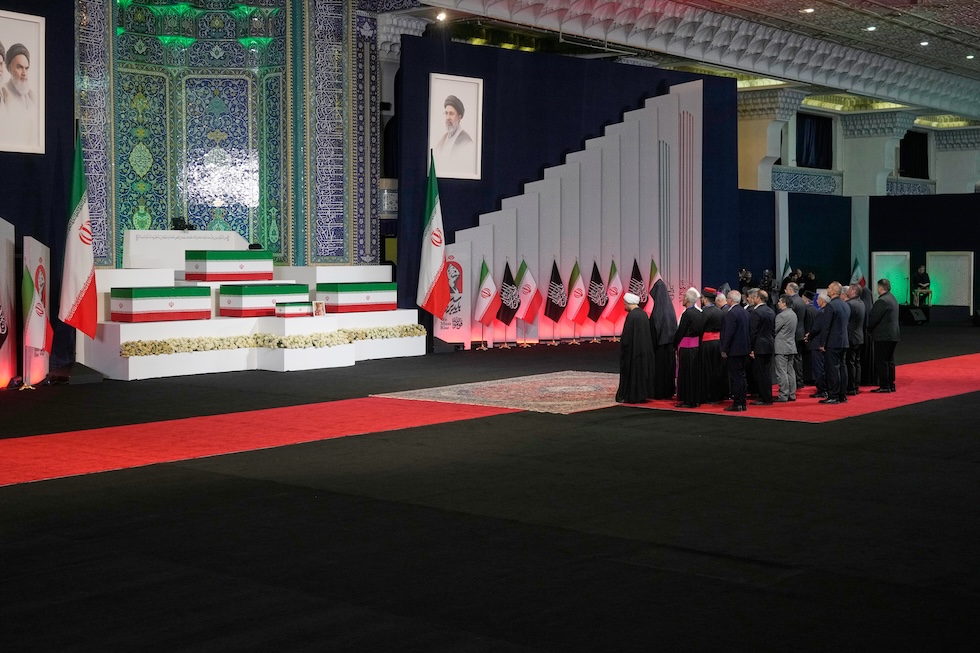 Un gruppo di leader religiosi iraniani e altri fedeli rende omaggio alle bare dell'ayatollah Ali Khamenei e dei membri della sua famiglia durante una cerimonia che precede i funerali, nella moschea dello Scià (AP Photo/Vahid Salemi)
